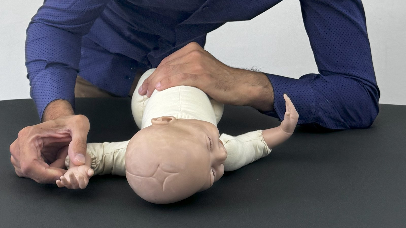 Le mani di un osteopata pediatrico sulla testa e sul collo di un neonato